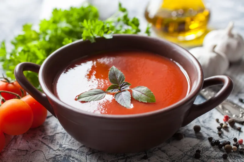 soupe de tomates avec un basilic dans un bol sur une table, mise au point sélective