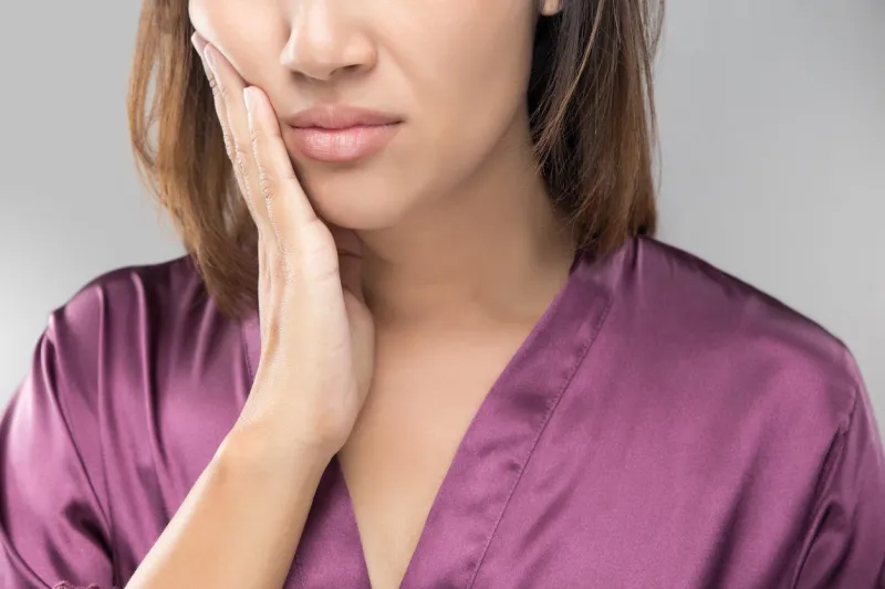 closeup of beautiful young woman suffering from toothache, dental health and care, people with teeth problem concept