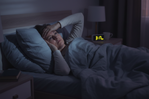personne d'une quarantaine dans son lit la nuit, éveillée à cause d'une insomnie