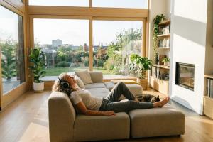 Femme allongée dans son salon écoutant de la musique