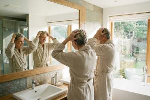 Couple en peignoirs dans une salle de bain 