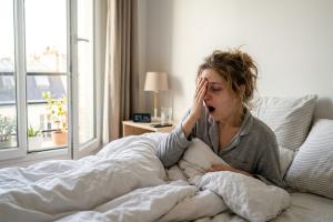 Personne dans son lit visiblement fatiguée au réveil
