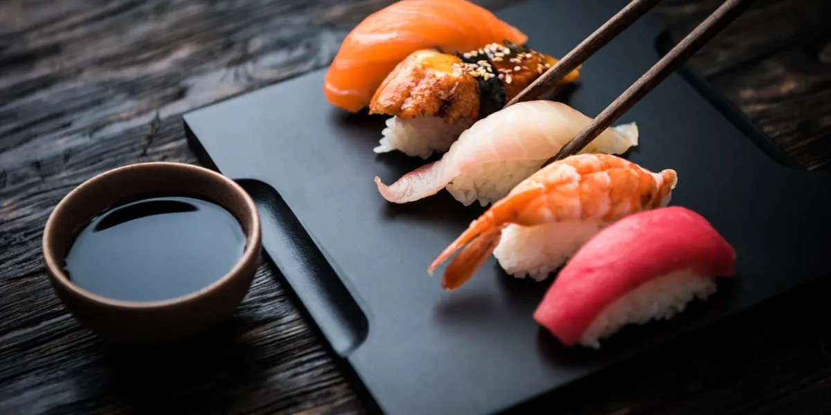 close up of sashimi sushi set with chopsticks and soy on black background