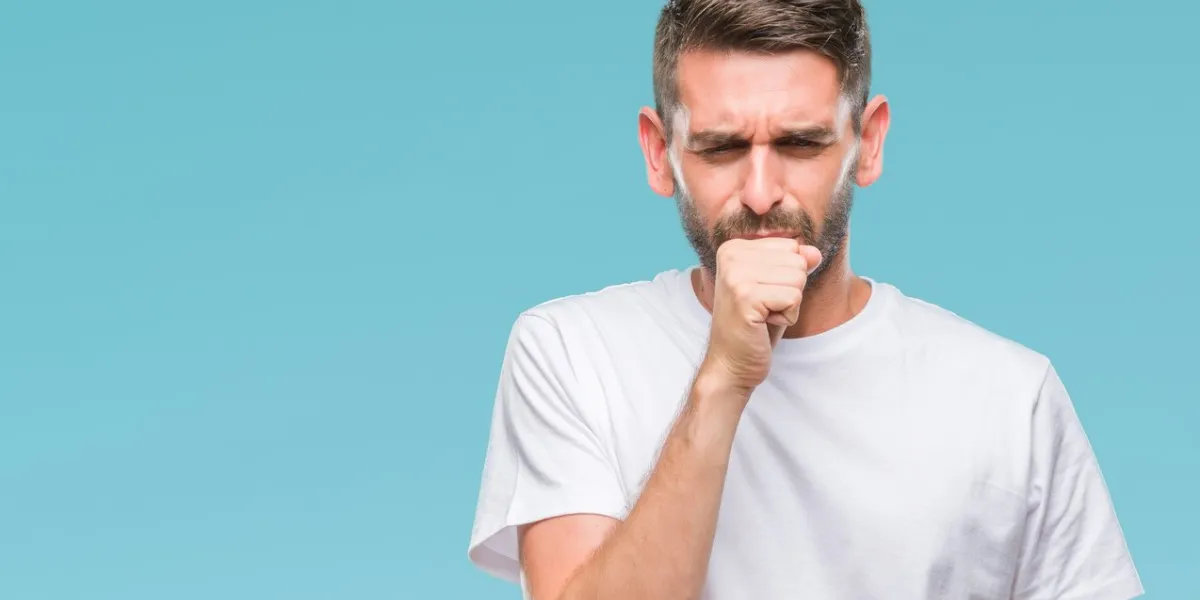 young handsome man over isolated background feeling unwell and coughing as symptom for cold or bronchitis healthcare concept