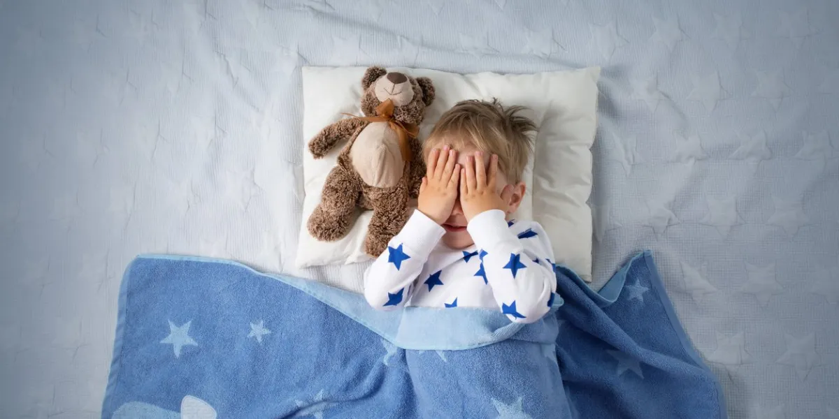 three years old child crying in bed sad boy on pillow in bedroom
