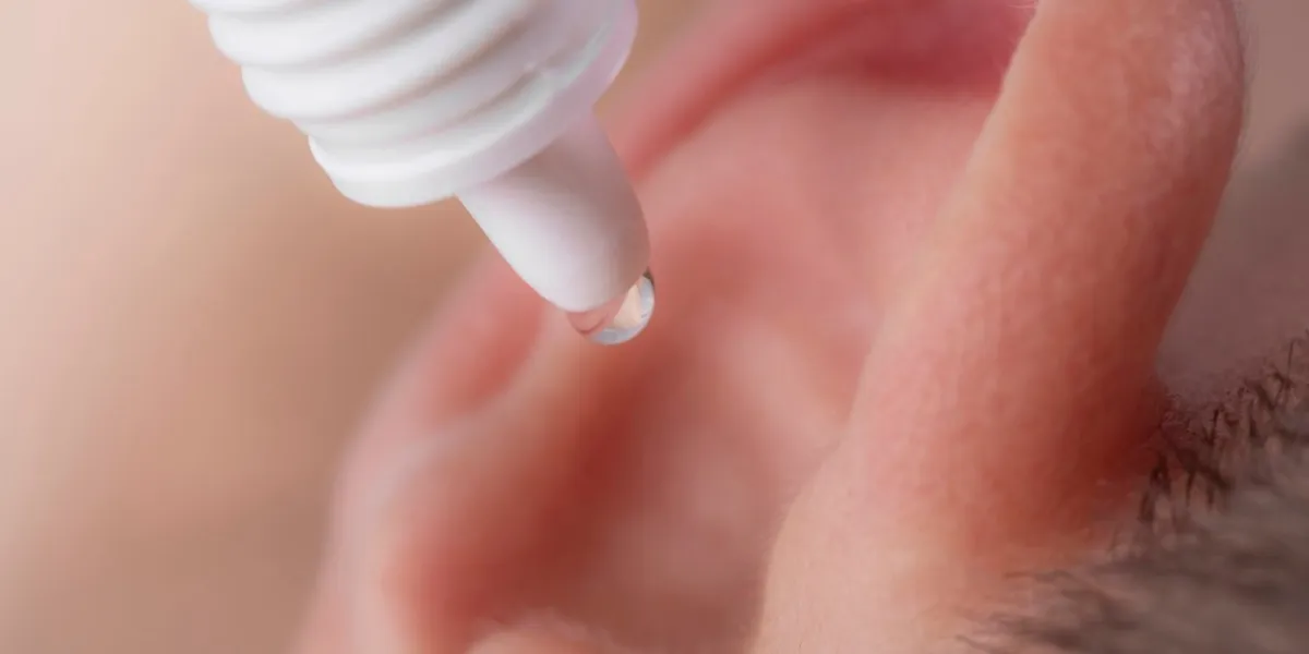 medical pipette with a drop of medication over the patient's ear ear diseases