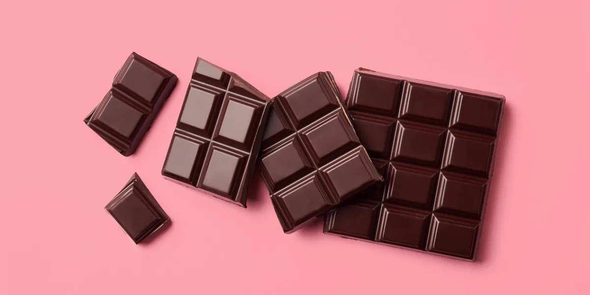 dark chocolate on pink background top view