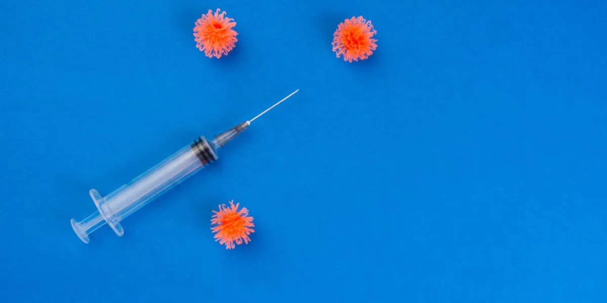 syringe and three simulated virus on blue background, diseased and recovery concept