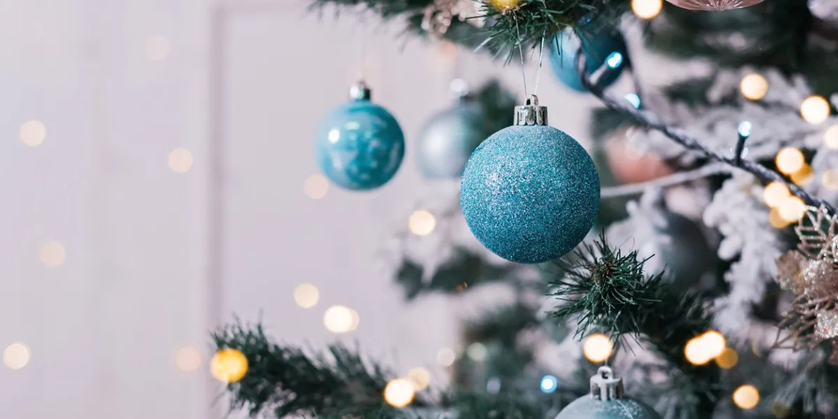 christmas tree with toys in blue and golden color decorated white room with christmas tree and blue toys