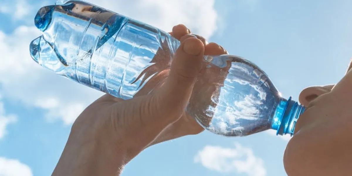 woman drinking water after her workout