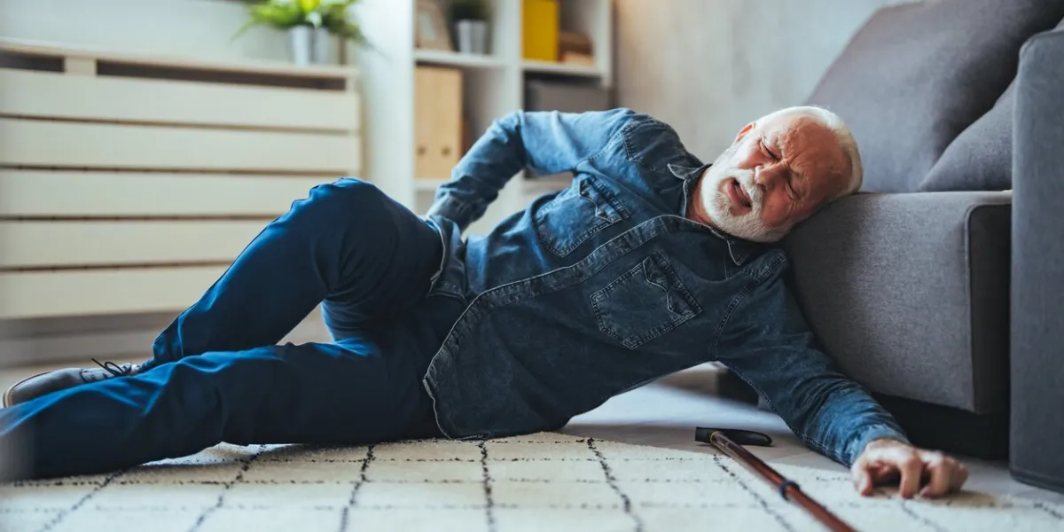 senior man falling on the ground with walker in living room at home elderly older mature male having an accident headache for emergency help support from hospital insurance health care
