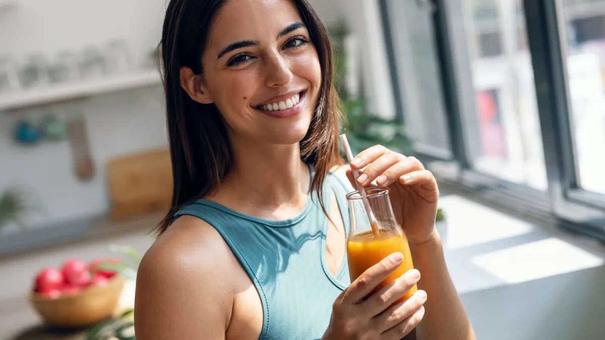 Femme qui boit un jus d'oranges