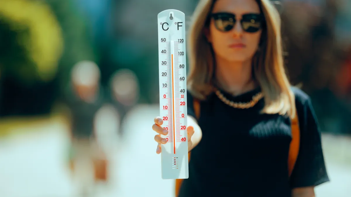 femme qui tient un thermomètre