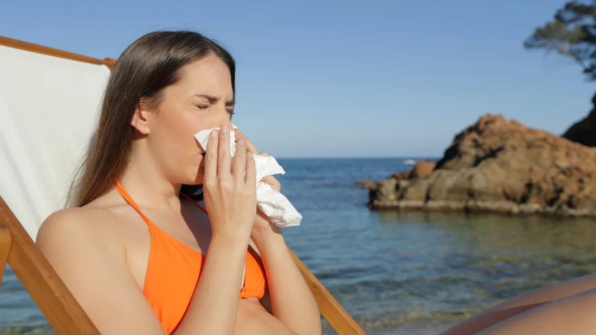 femme qui se mouche à la plage