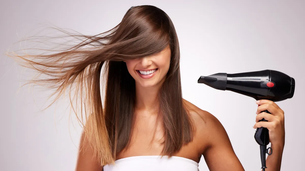 femme qui utilise un sèche-cheveux