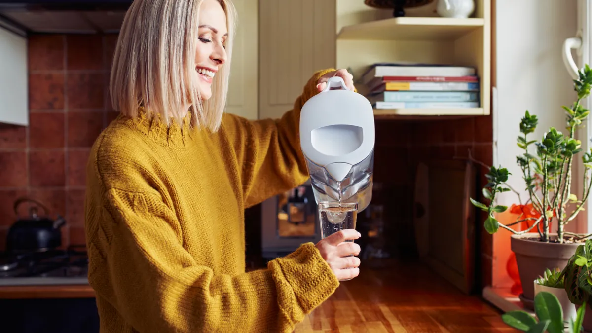 femme qui utilise une carafe filtrante