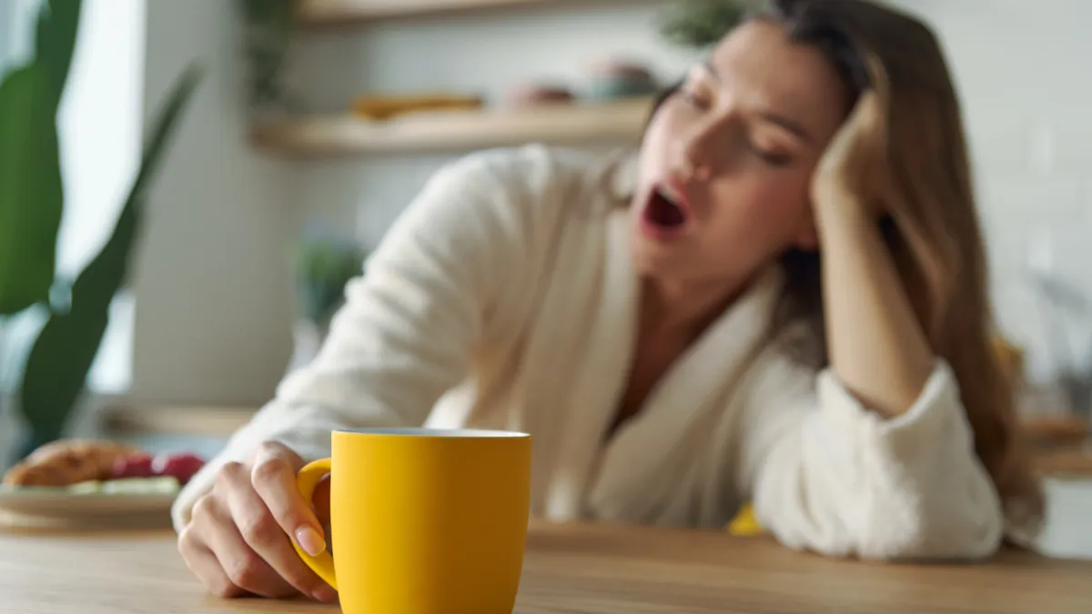 femme qui baille devant un tasse