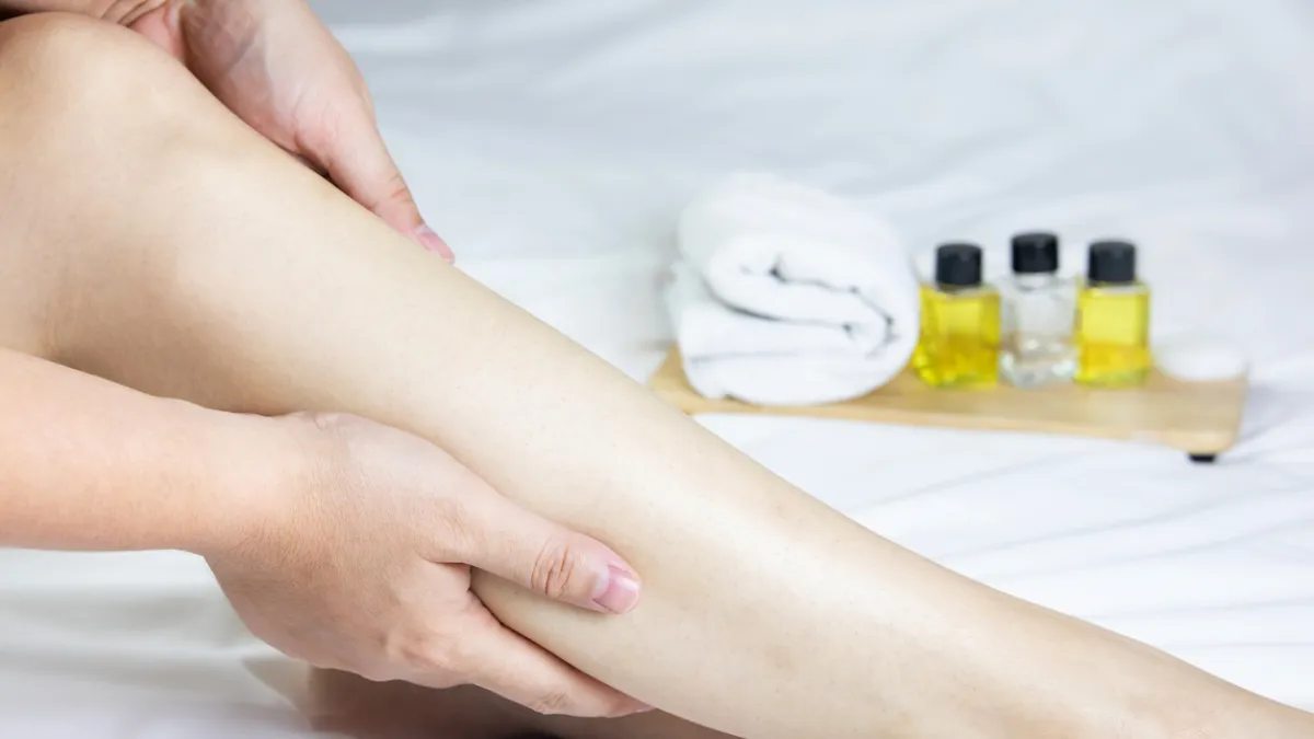 femme qui se masse les jambes