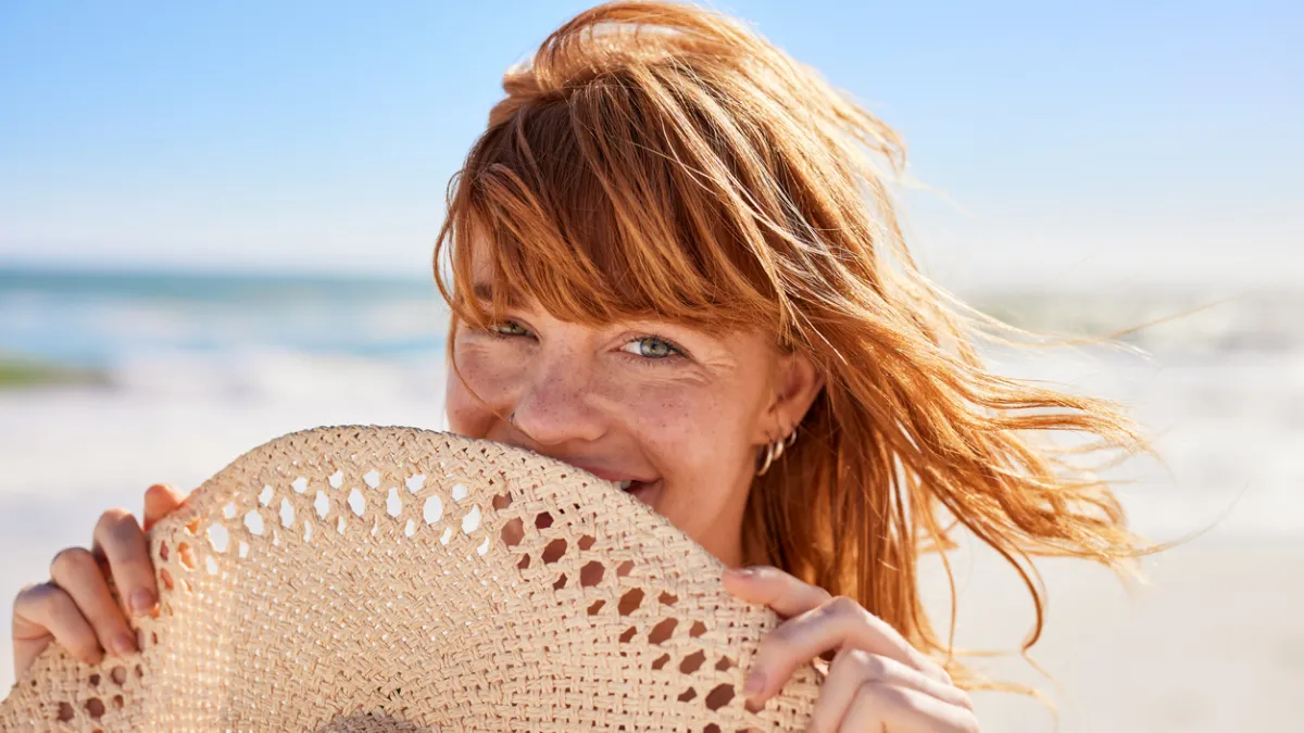 femme en bord de mer avec un chapeau
