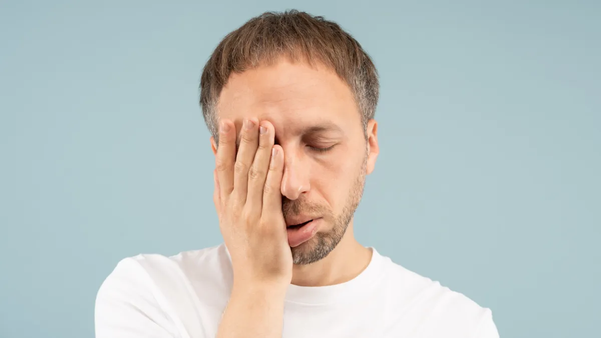 homme qui se tient le visage