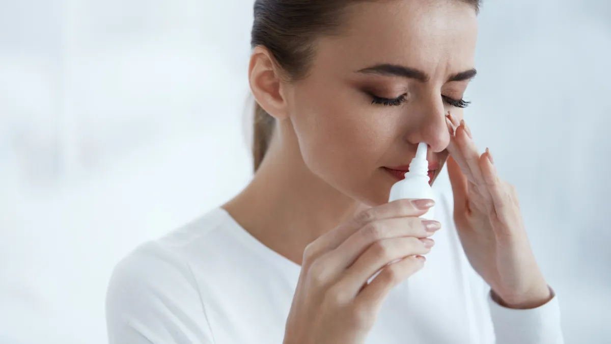 femme qui utilise un spray nasal
