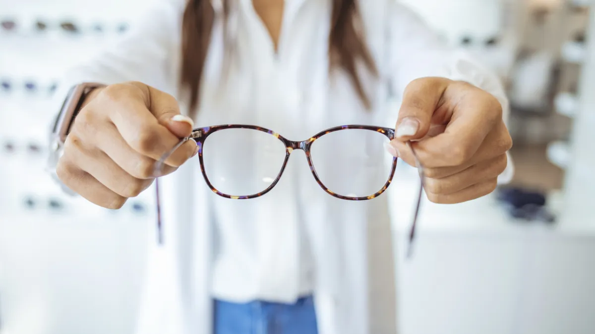 opticienne qui tient des lunettes