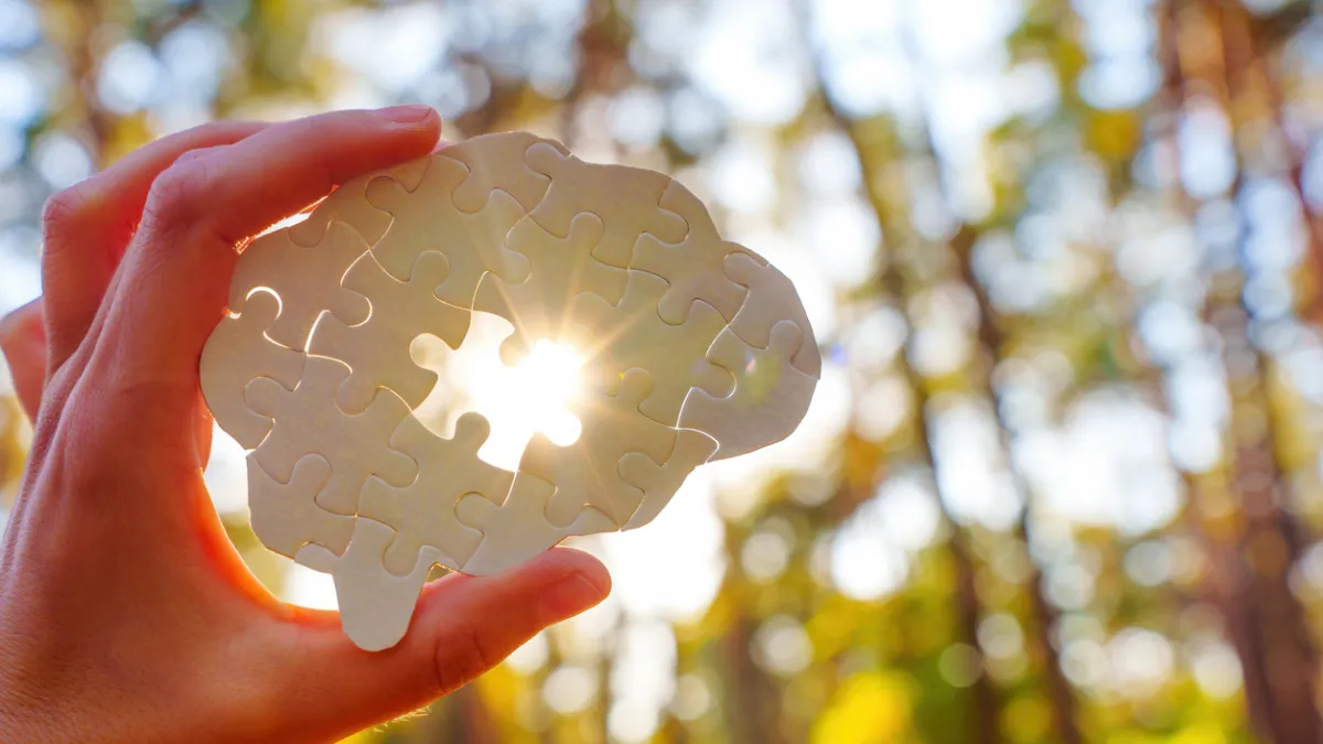 main tenant un puzzle en forme de cerveau