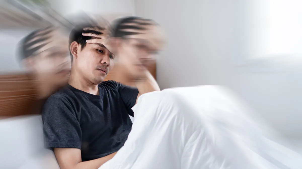 homme dans un lit qui a un vertige