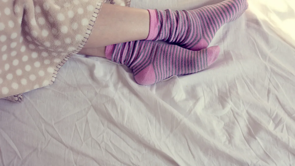 femme qui porte des chaussettes au lit