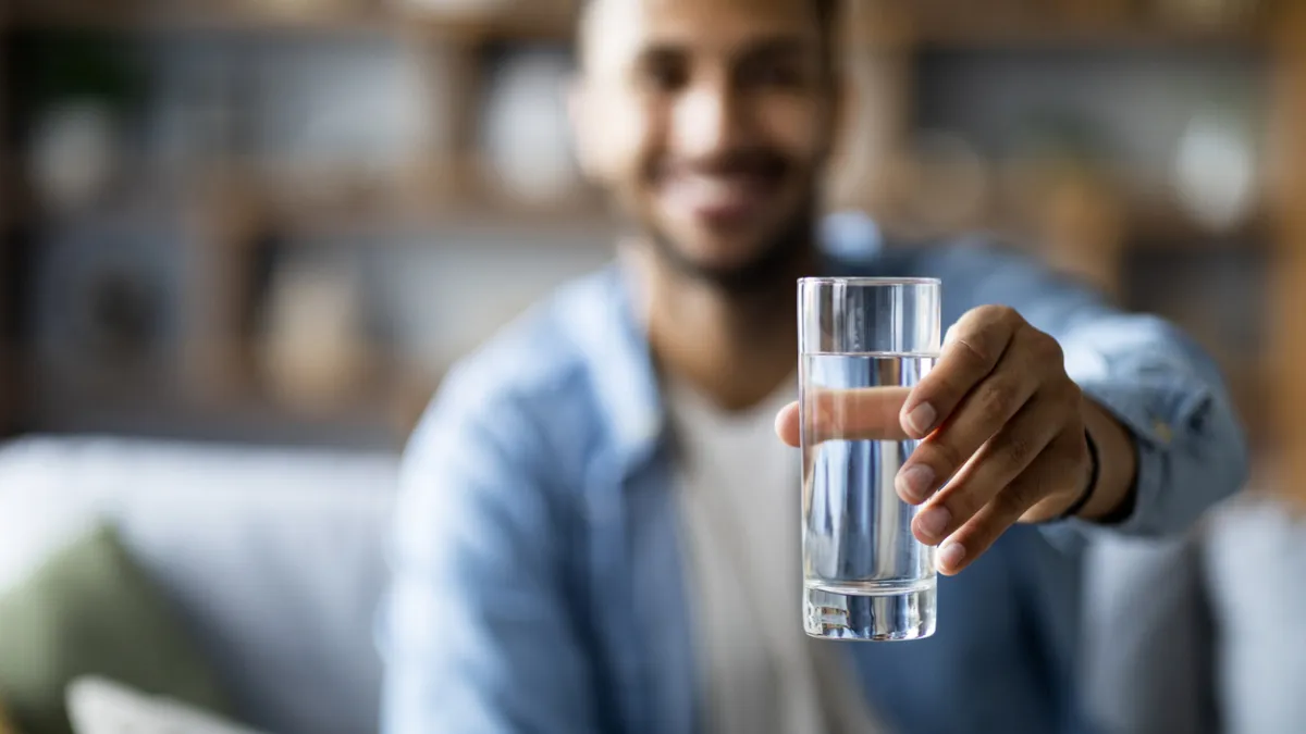 homme qui boit un verre d'eau