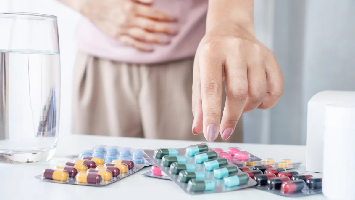 personne qui souffre de brûlures d'estomac et qui prend un médicament