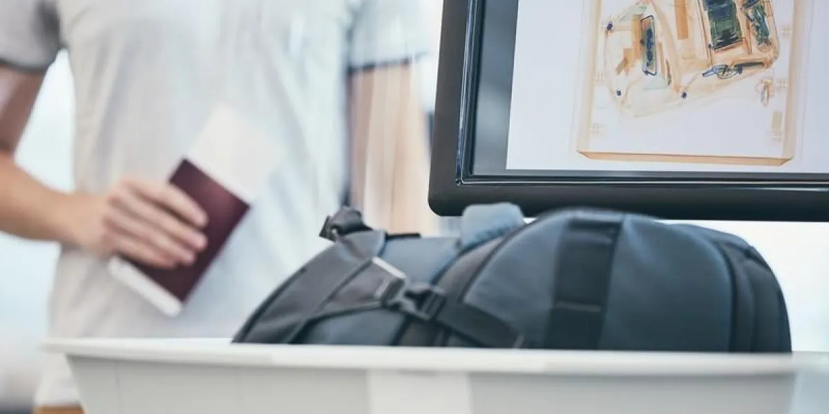 airport security check young man holding passport and waiting for x-ray control his luggage