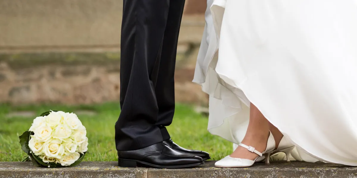 les jambes de la mariée et le marié et bouquet de mariée