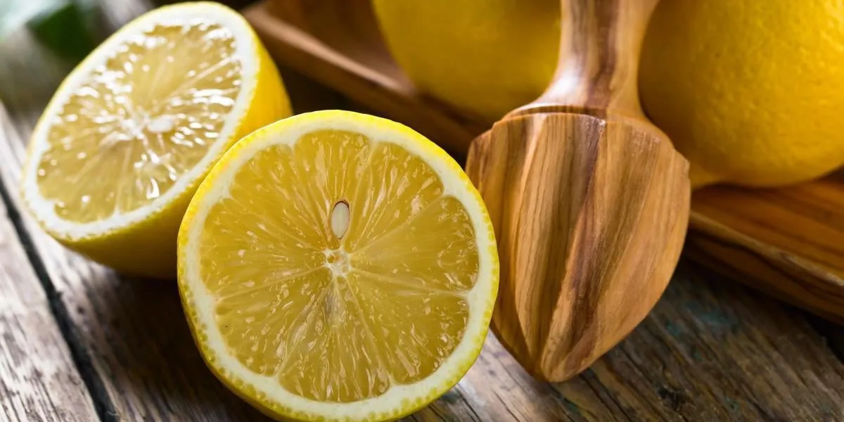 citrons mûrs juteux et vieux presse-fruits en bois