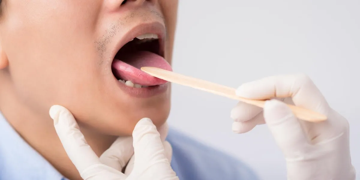 close-up image of male patient having check-up of his throat