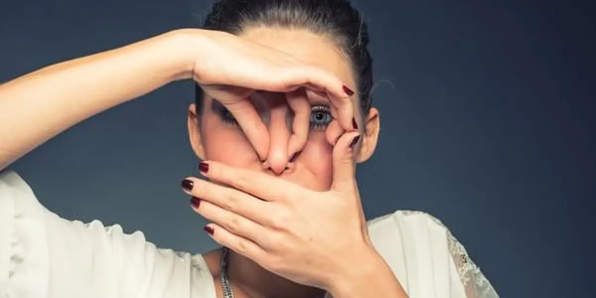 jeune femme brune, tenant son nez à cause d'une mauvaise odeur