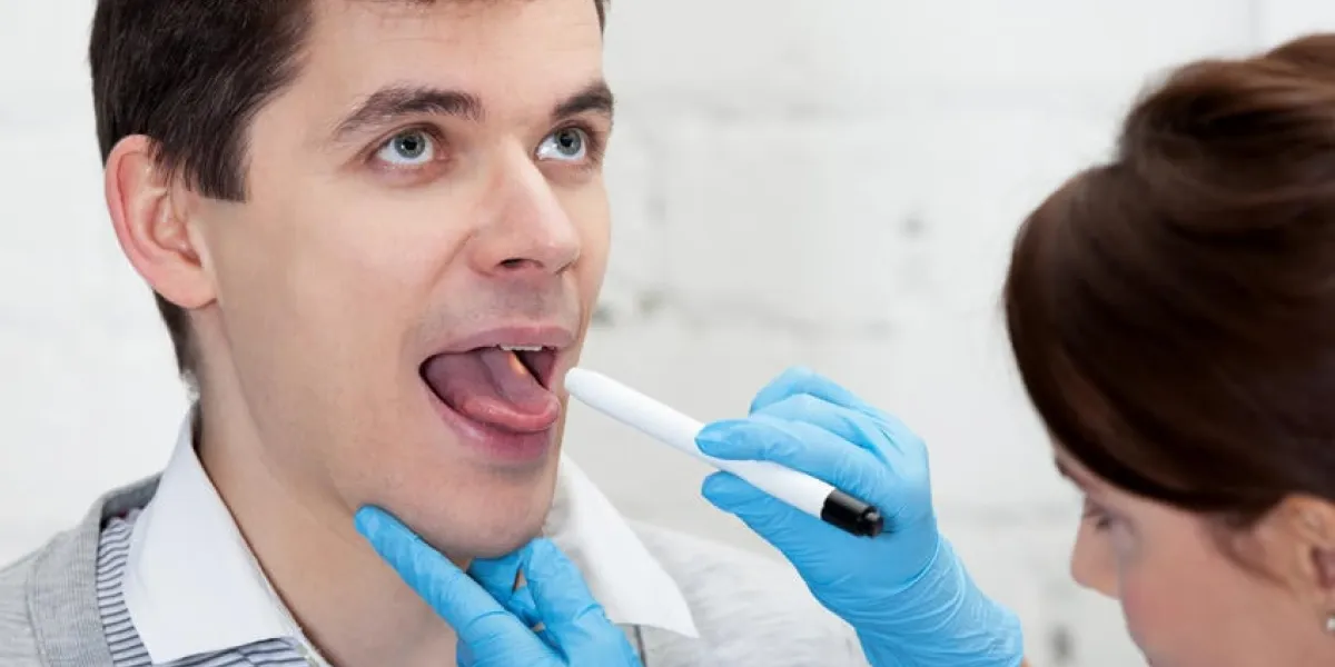 le médecin vérifie la gorge d'un patient