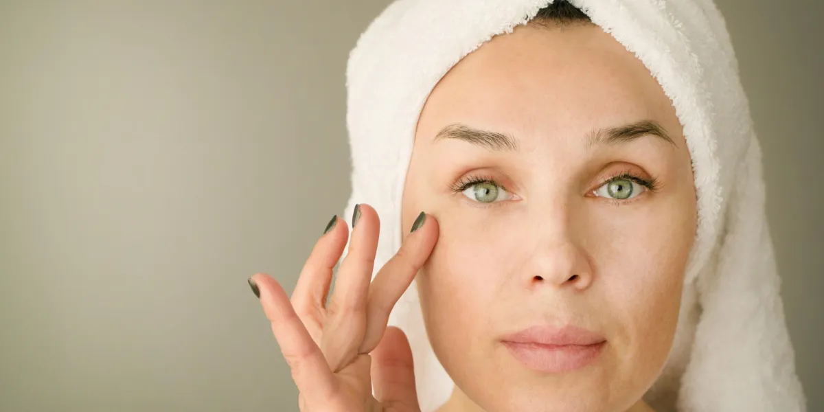 the woman of forty years puts a cream under eyes