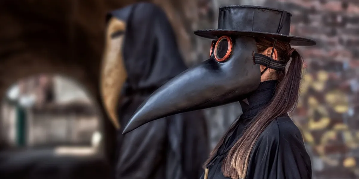 a couple in love in costumes and masks of a plague doctor during an epidemic