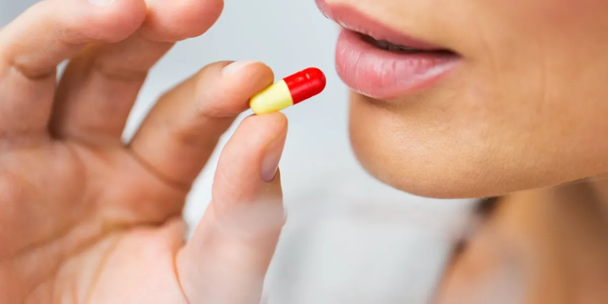medicine, health care and people concept - close up of woman taking in pill