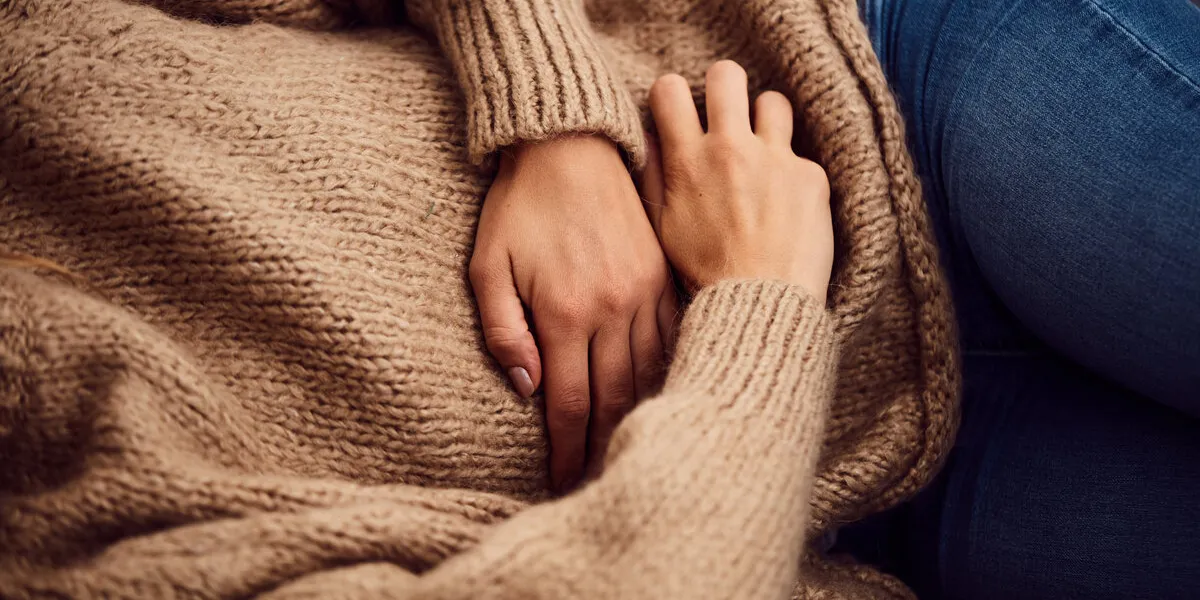 woman having stomach issues   problems while lying on the couch