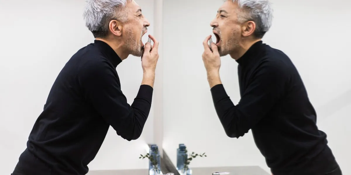 a middle-aged man is taking care of his throat with a throat medicine