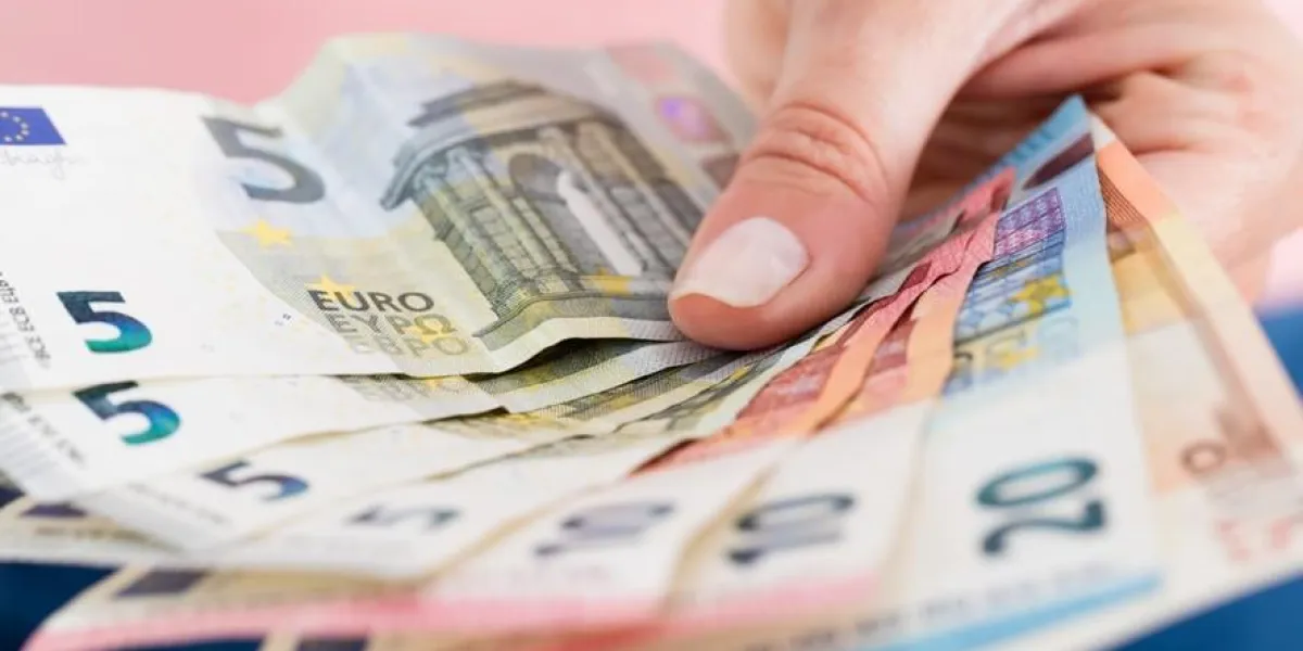 gros plan, de, personne, main, projection, éventé, euro, monnaie, notes, sur, arrière-plan rose