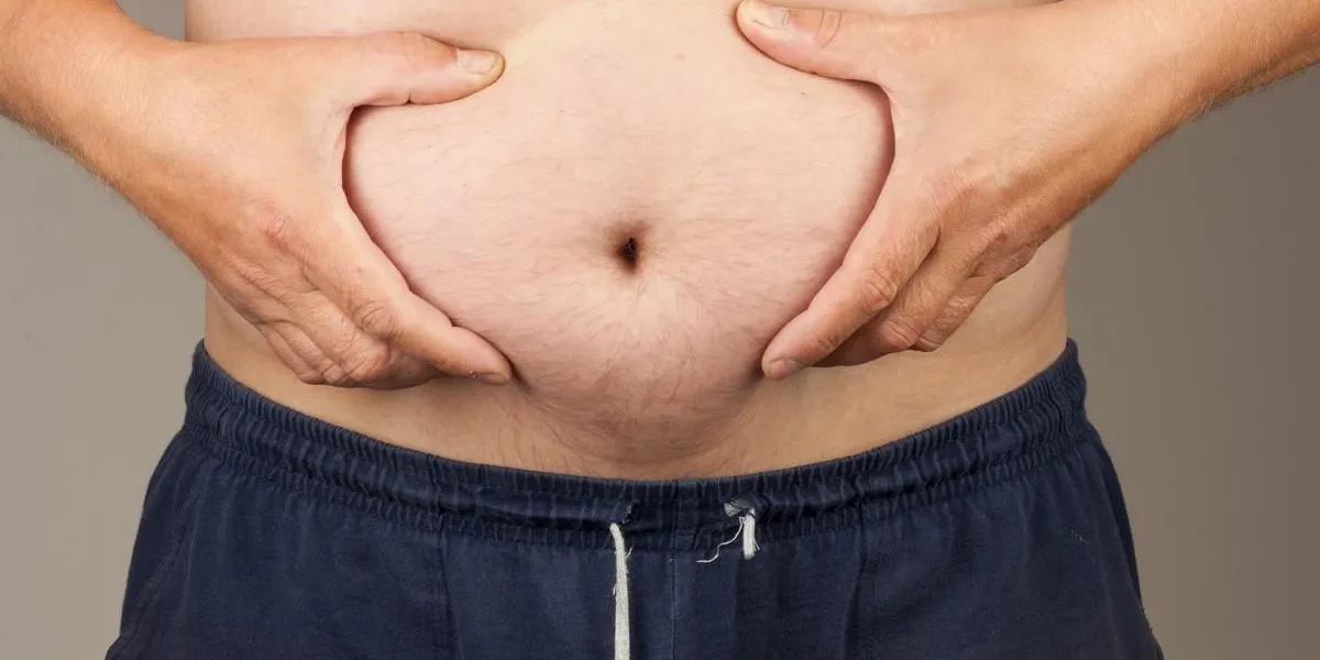 obese fat man man is holding his too fat tummy obesity health hazard health care and people concept