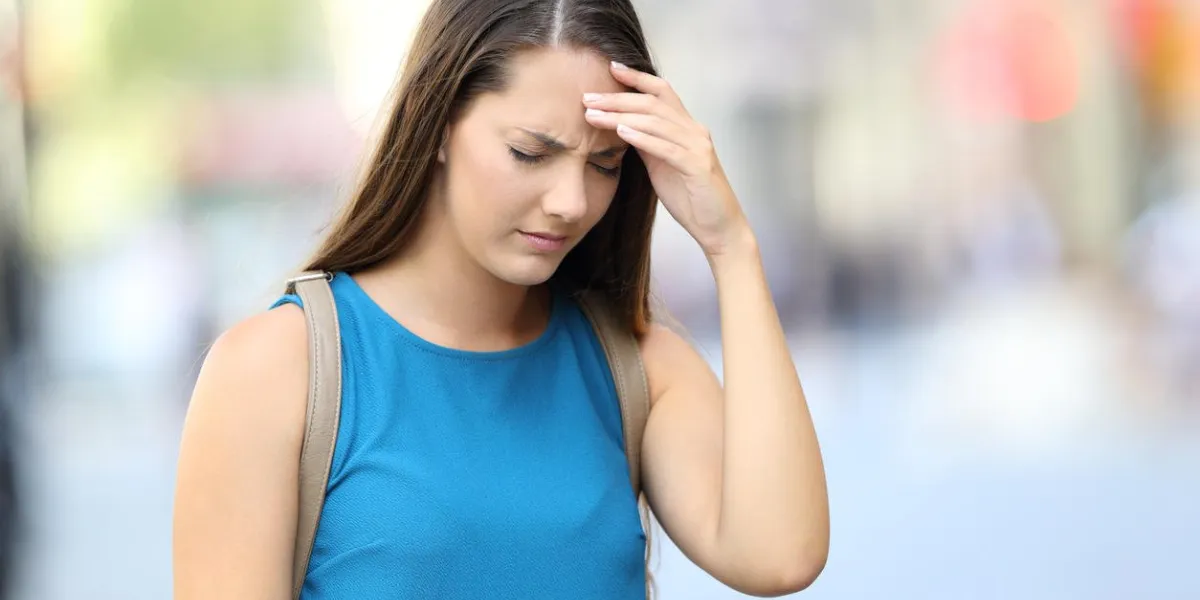 single woman suffering headache walking on the street