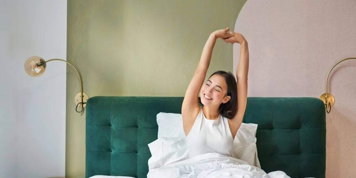 beautiful,asian,woman,lying,in,her,bedroom,on,bed,,stretching