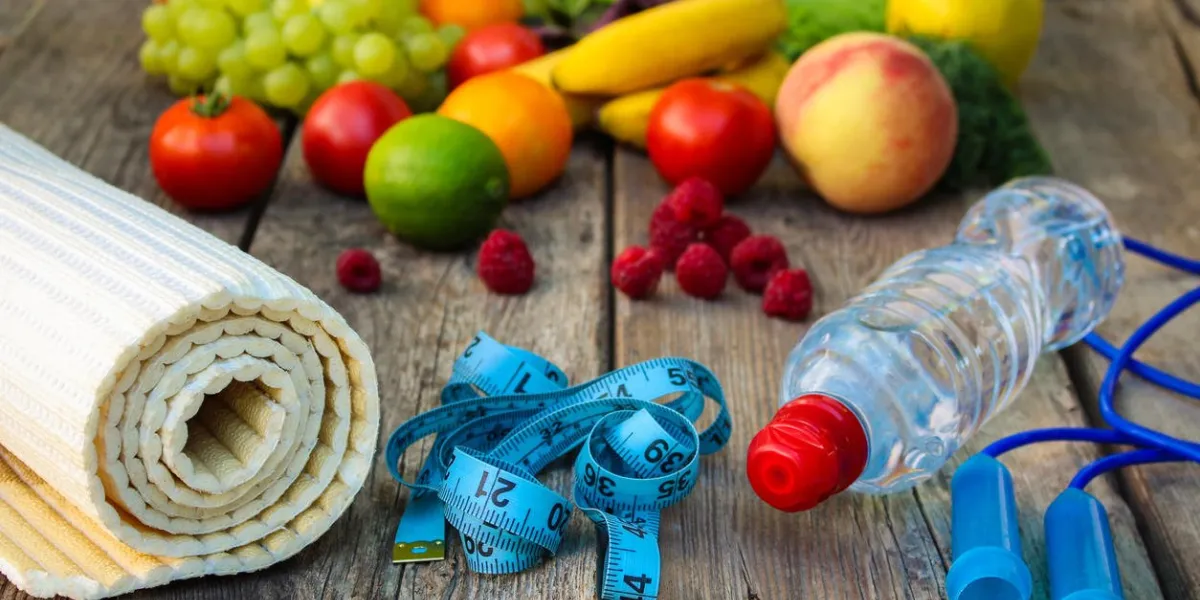 fruits, vegetables and sports goods on wooden background