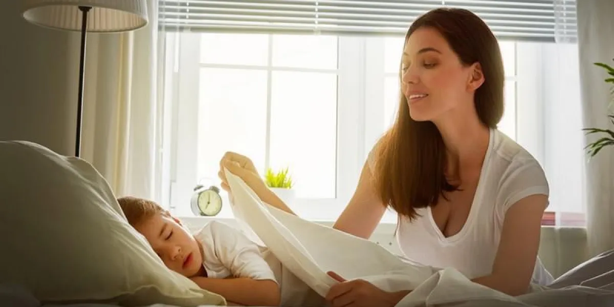 portrait de jeune mère couvrant la petite fille endormie avec couverture