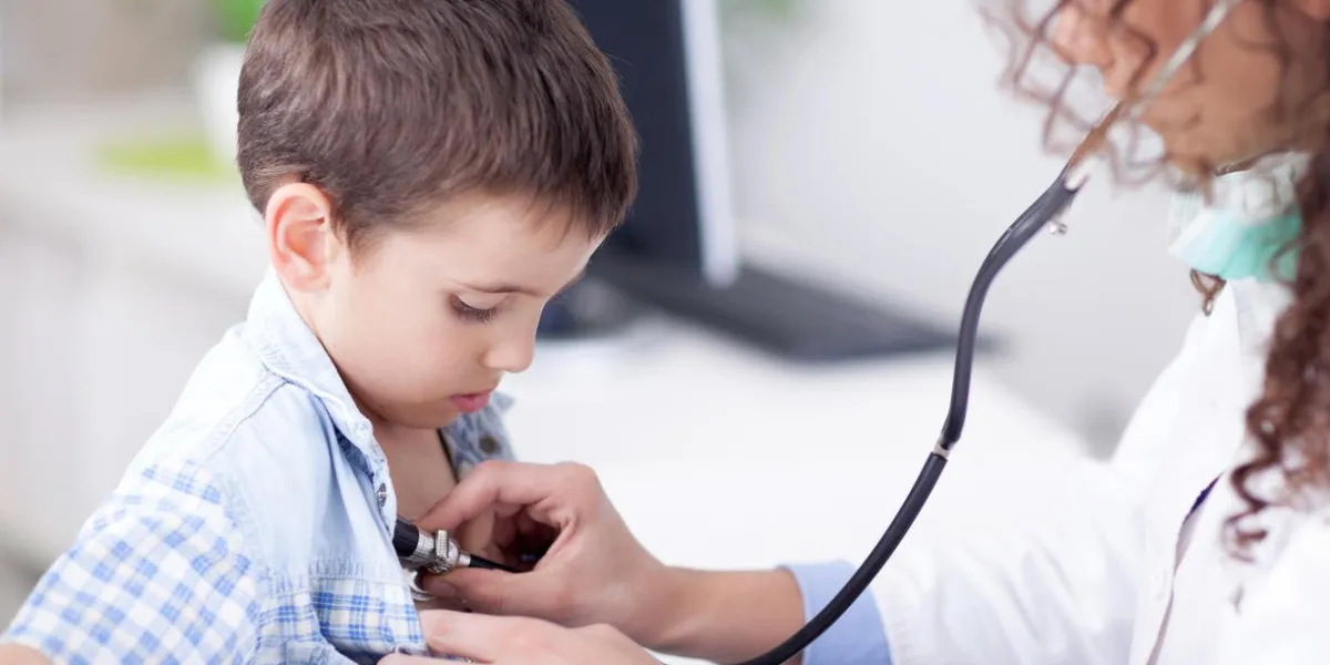 sympathique femme médecin examinant un petit garçon