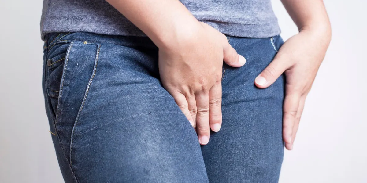 woman with hands holding her crotch